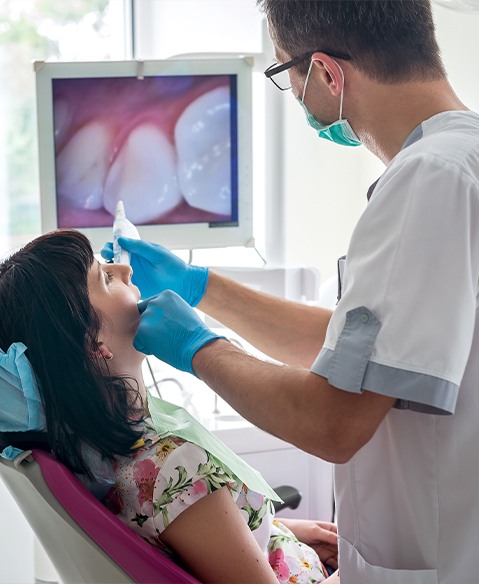 Dentist using intraoral camera to examine dental patient's smile